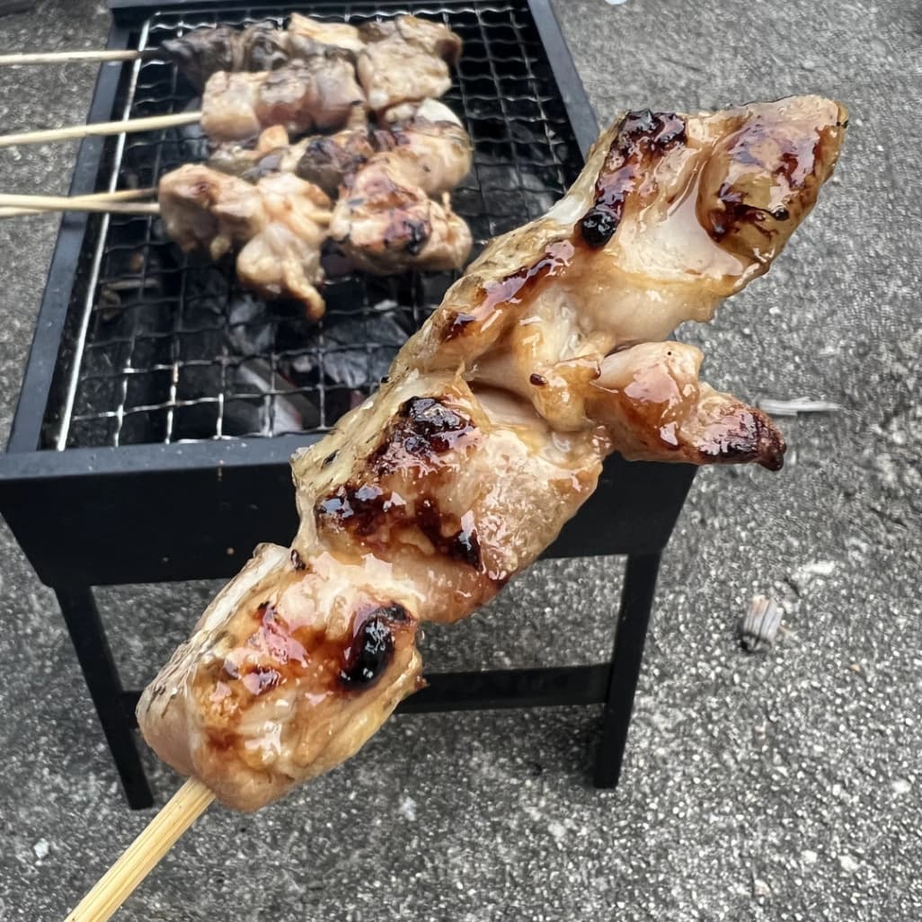 美味しそうに焼けたコストコさくらどり焼鳥用鶏もも串を手に持っている画像