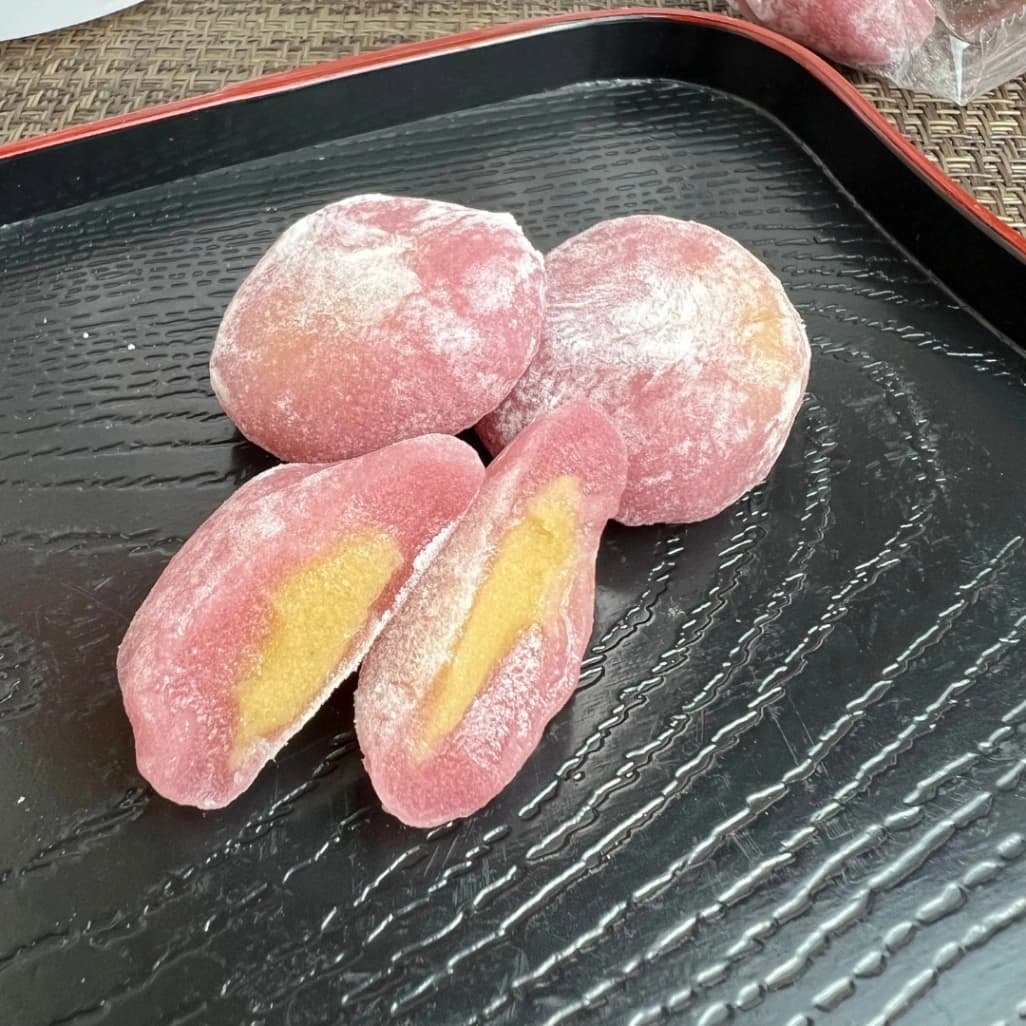 久世福「ひとくち大福 焼き芋」の断面。紫色のもち生地の中に黄色い焼き芋あん