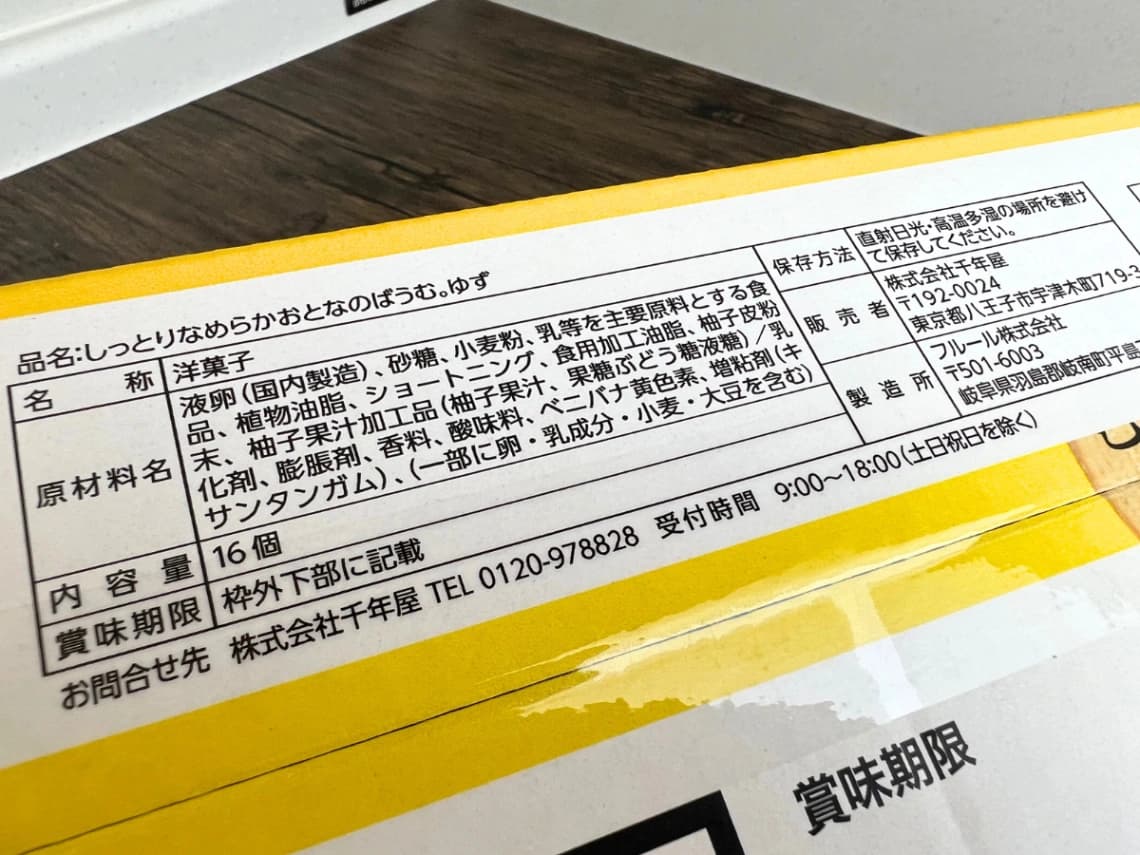 コストコ「千年屋 しっとりなめらかおとなのばうむ。ゆず」の食品表示ラベル。原材料名、アレルギー表示、内容量16個、保存方法を確認できる