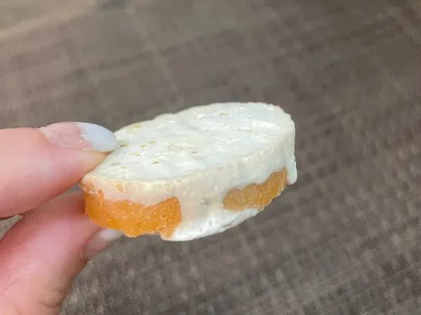 バゲットにチーズをのせたトッピング準備のアップ。手に持って厚みが分かるカット