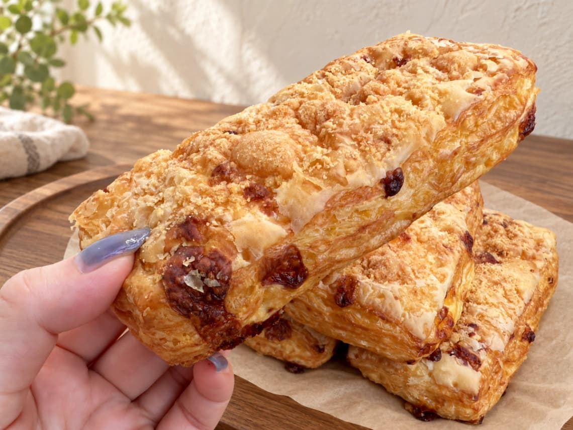 コストコ「チーズパフデニッシュ」を手に持った様子｜表面のチーズと香ばしい焼き色
