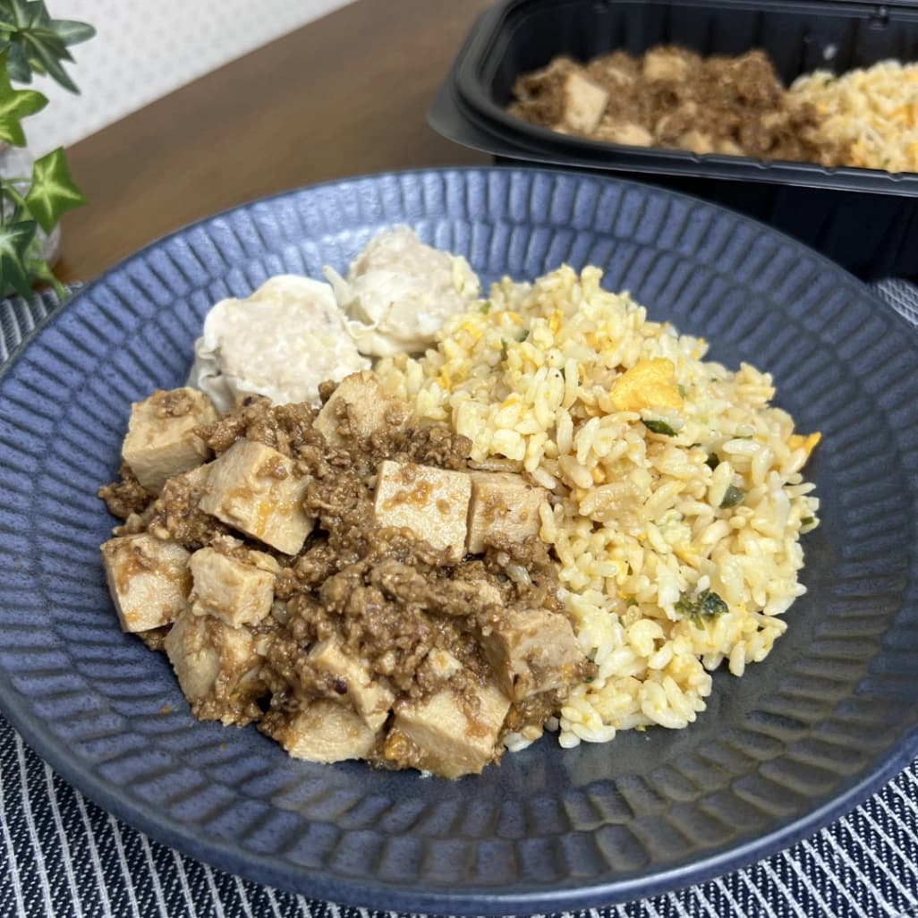 コストコの麻婆チャーハンを皿に盛り付けた実食写真。麻婆豆腐と卵チャーハン、焼売を一皿で楽しめる
