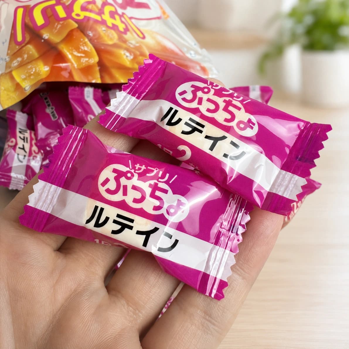 手に持ったコストコUHA味覚糖サプリぷっちょルテイン一個のサイズ感