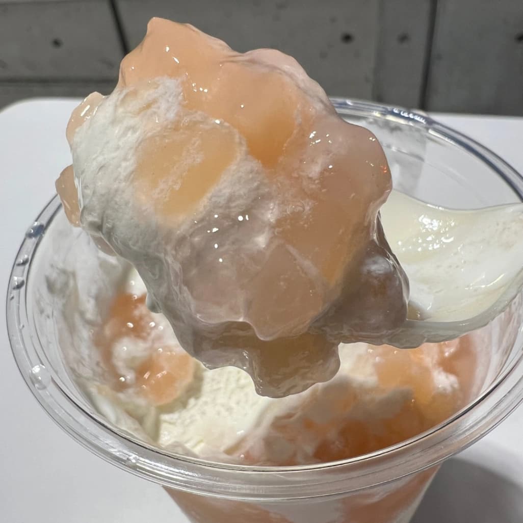 コストコフードコートピーチサンデーをスプーンですくっている画像