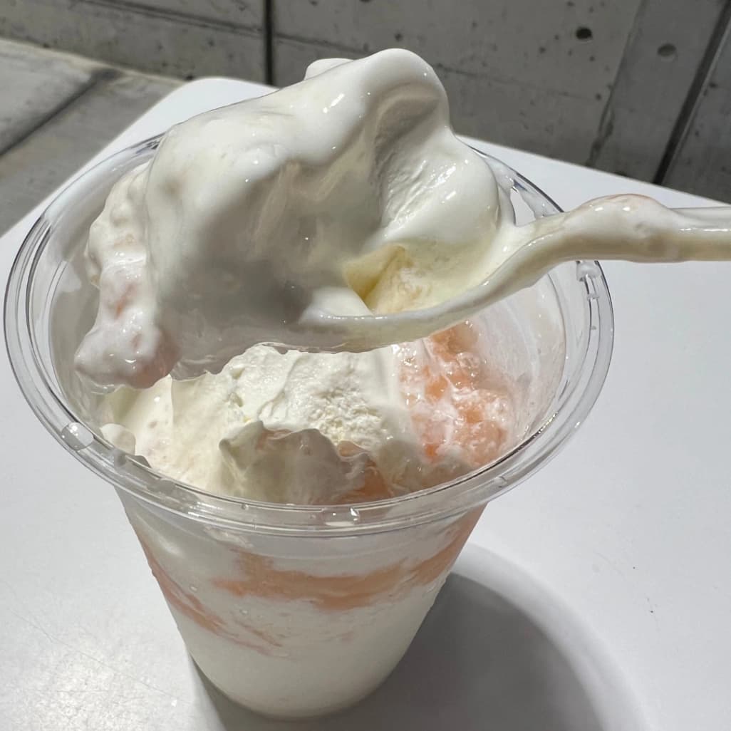 コストコフードコートピーチサンデーのソフトクリーム部分をスプーンですくってる画像