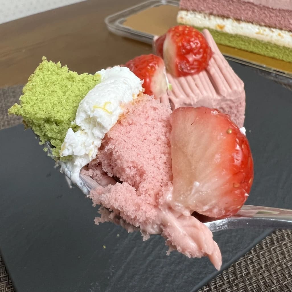 コストコのスプリングバーケーキをフォークで持ち上げた写真。いちごと3層の断面が見える