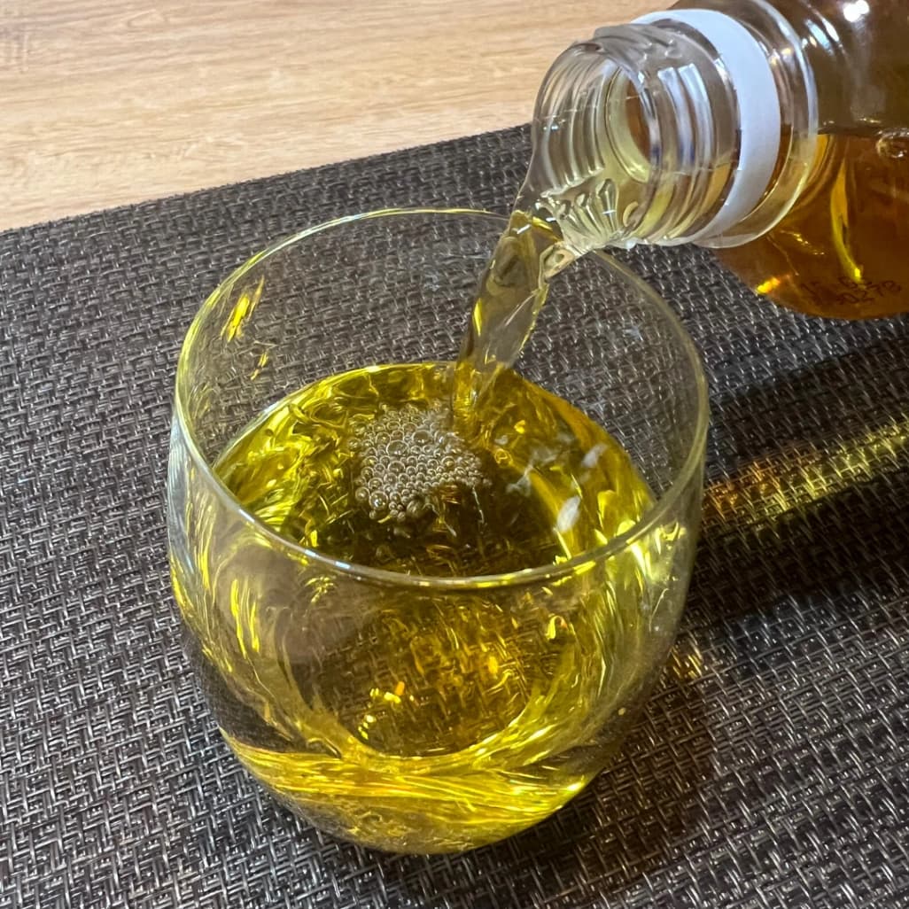 お茶屋さんの緑茶 500ml x 24本 ラベルレスをコップに注いでいる画像