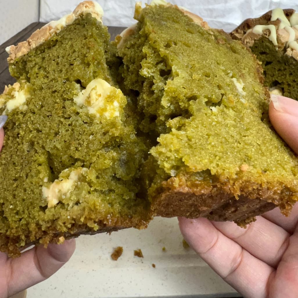 コストコ抹茶ホワイトチョコローフを手で半分に割っている画像