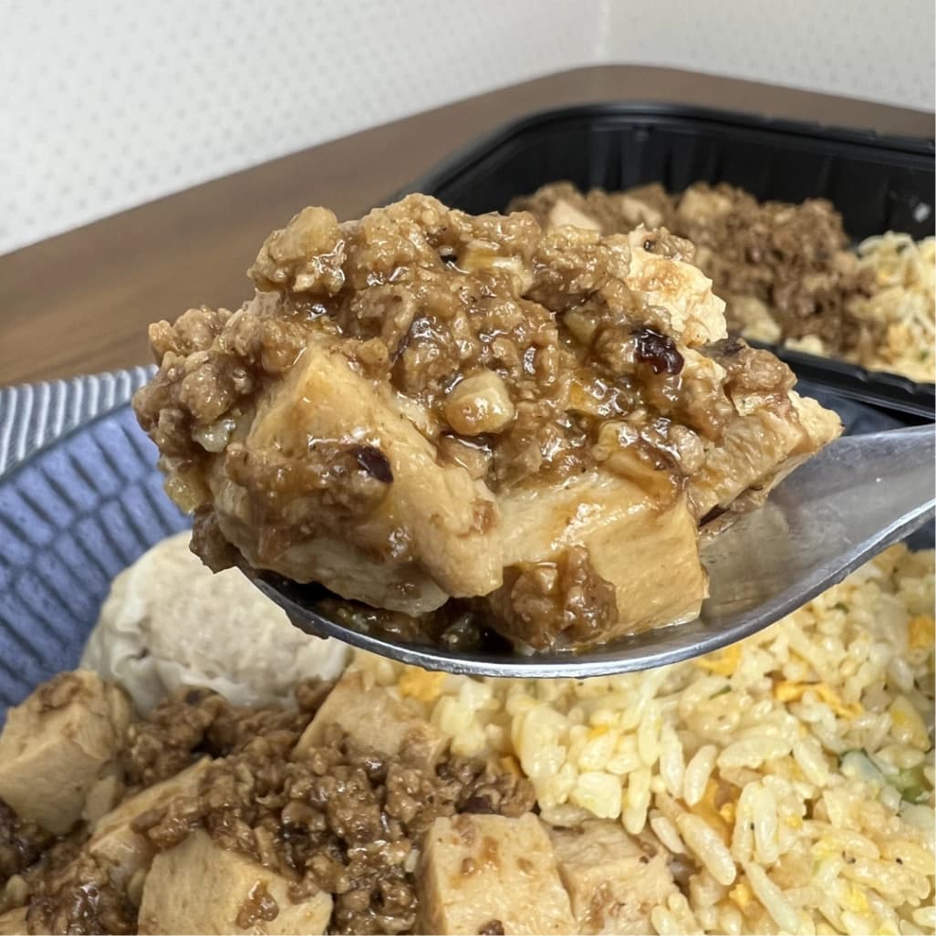 コストコ麻婆チャーハンの麻婆豆腐をスプーンですくったアップ。ひき肉たっぷりで辛さのある味わい