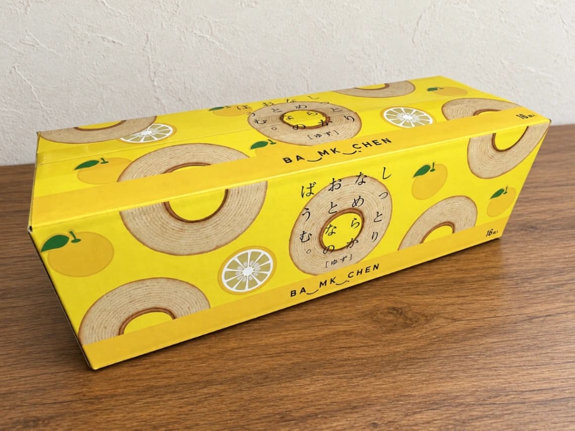 コストコ新商品「千年屋 おとなのばうむ。ゆず」16個入りの黄色いパッケージ。ゆずとバウムクーヘンが描かれた外箱