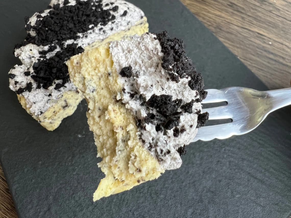 コストコのクッキークリームチーズケーキをフォークで持ち上げた断面・チーズケーキ生地とクリームの食感がわかるアップ写真