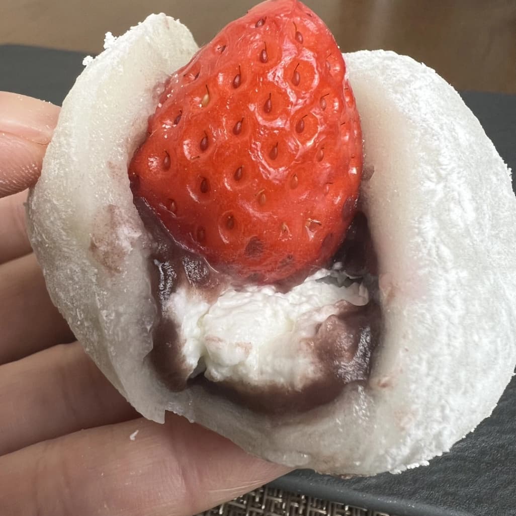 コストコのいちご大福を手に持ち、いちごとホイップクリームの断面を見せた写真