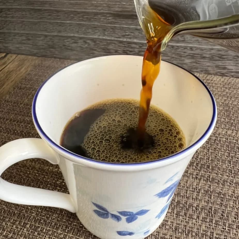 カップにコーヒーを注いでいる画像