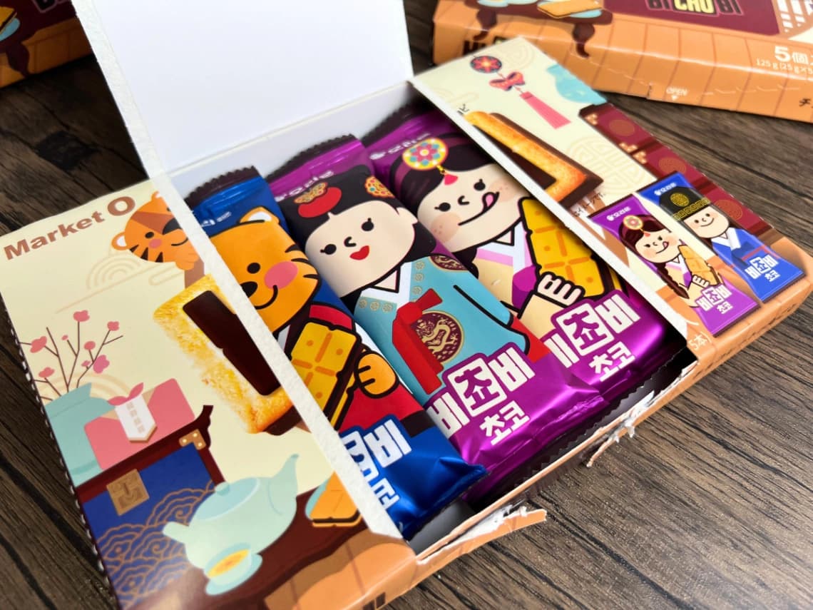 コストコのMarket O「ビチョビ」を開封した様子。箱の中に青色と紫色の可愛いキャラクターデザインの個包装チョコビスケットが並んでいる