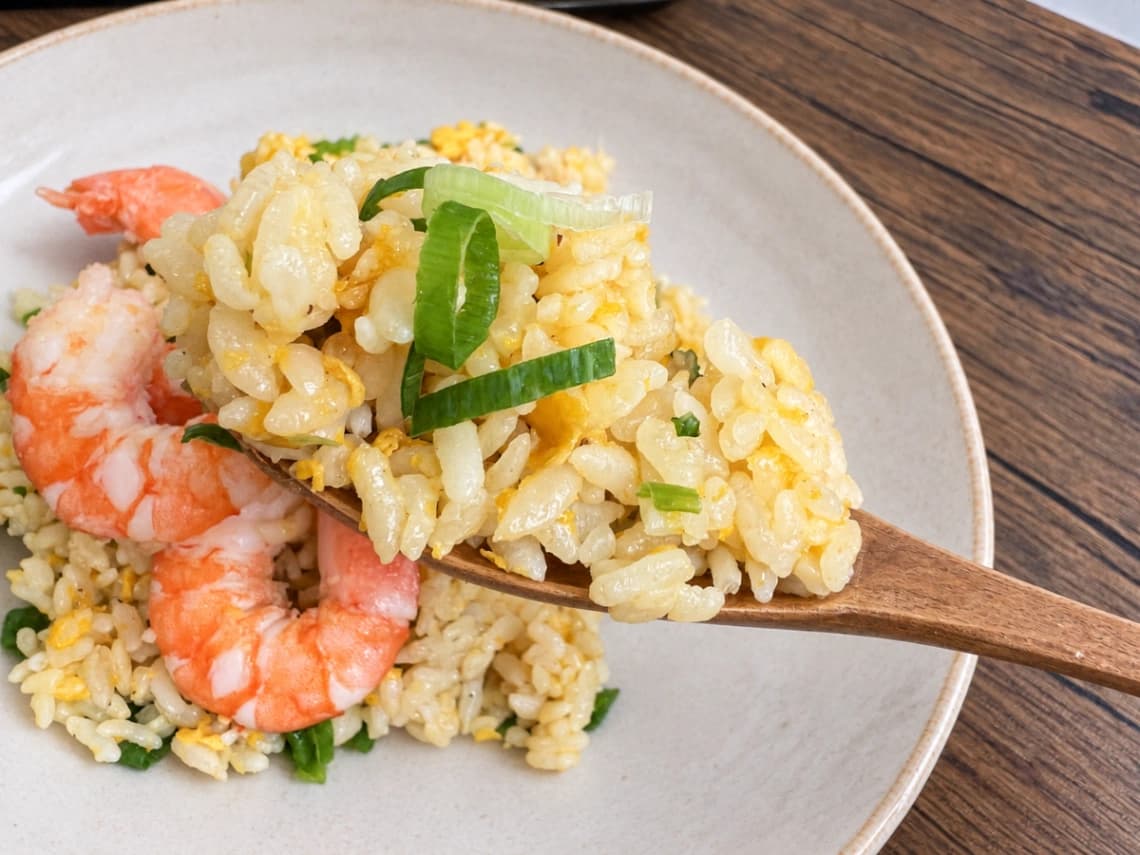 コストコ にんにくエビ炒飯 木製スプーンですくったご飯