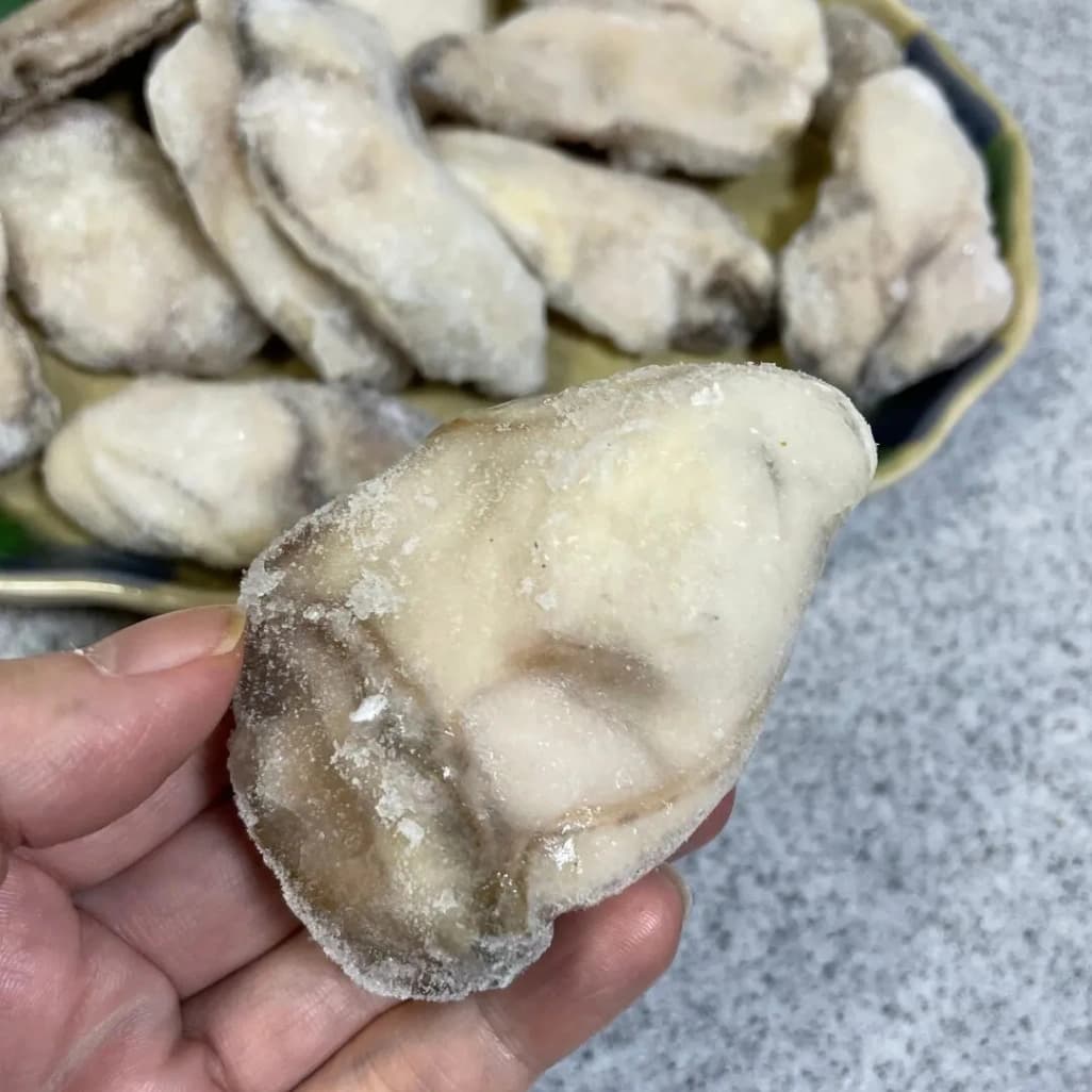 コストコ広島産冷凍牡蠣一個を手に持った画像