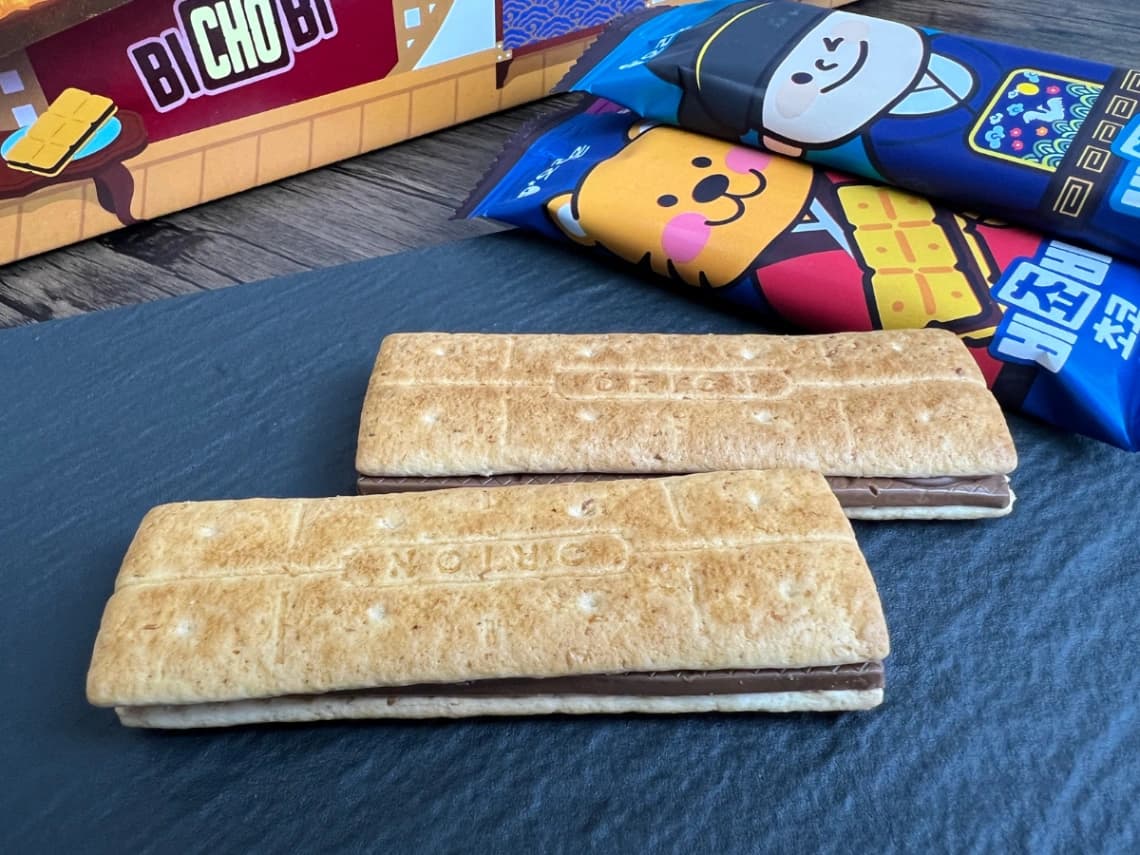 コストコ「ビチョビ」のチョコビスケット2本を並べた写真。長方形の香ばしいビスケットに厚みのある板チョコレートが挟まれたサンド菓子