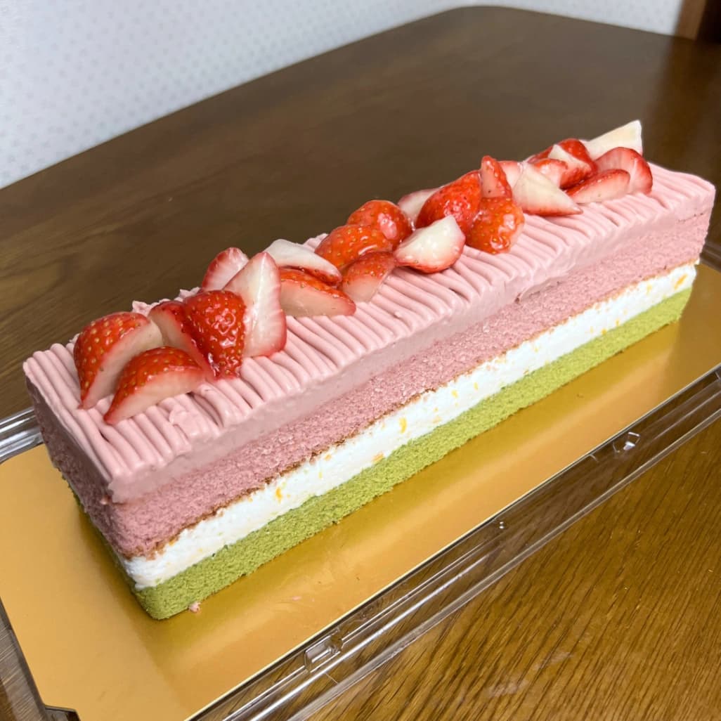 コストコのスプリングバーケーキ全体写真。いちごトッピングと3色の層がわかる