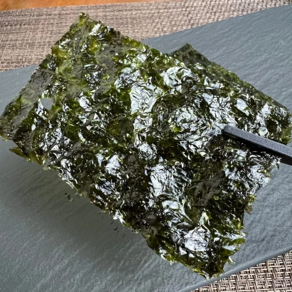 コストコ韓国海苔一枚を箸で掴んでいる画像